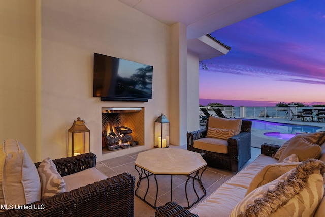 view of patio featuring an outdoor living space with a fireplace and a balcony