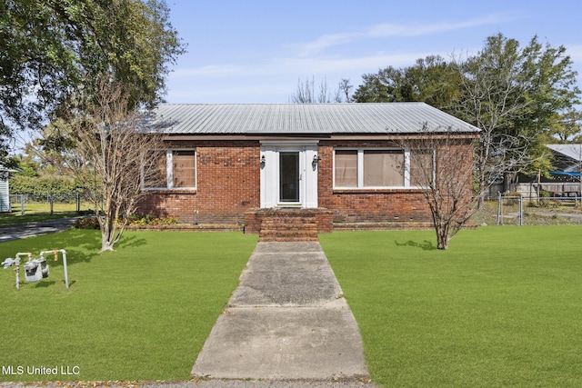 bungalow-style home with brick siding, metal roof, a front yard, and fence