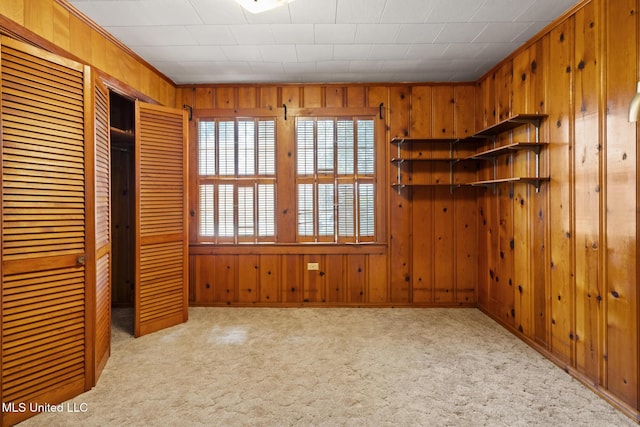 unfurnished bedroom featuring carpet floors and wooden walls