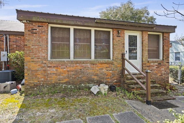 view of front facade featuring brick siding, entry steps, and metal roof