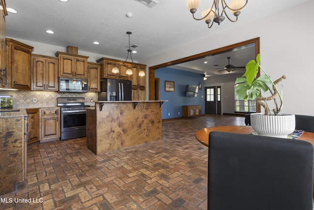 12219 County Farm Rd, Gulfport, MS 39503 - kitchen with stainless steel range, black microwave, refrigerator with ice dispenser, decorative backsplash, and a center island