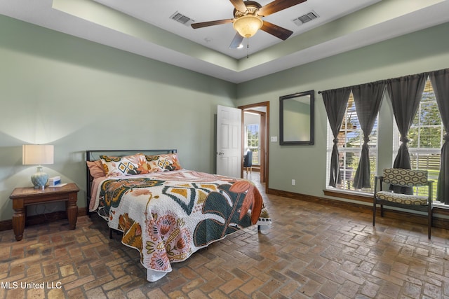 12219 County Farm Rd, Gulfport, MS 39503 - bedroom with brick flooring, a raised ceiling, and a ceiling fan