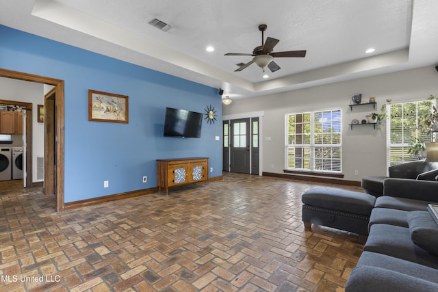 12219 County Farm Rd, Gulfport, MS 39503 - living area featuring a raised ceiling, independent washer and dryer, recessed lighting, plenty of natural light, and a ceiling fan