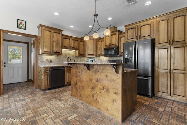 12219 County Farm Rd, Gulfport, MS 39503 - kitchen with black appliances, a kitchen breakfast bar, decorative backsplash, brick floors, and recessed lighting