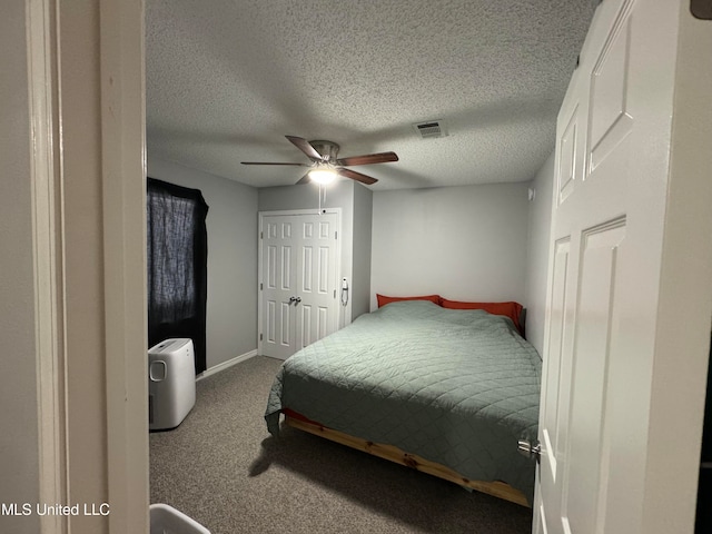 carpeted bedroom with a textured ceiling and ceiling fan