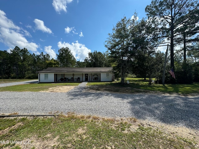 ranch-style house featuring covered porch, a front yard, and a garage