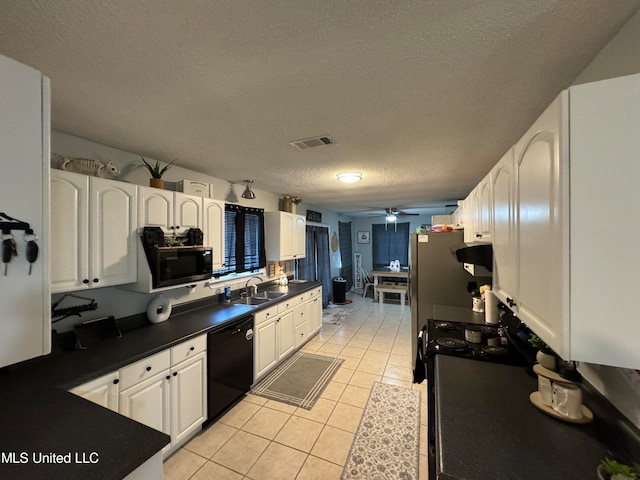 kitchen with white cabinets, black dishwasher, light tile patterned floors, a textured ceiling, and sink