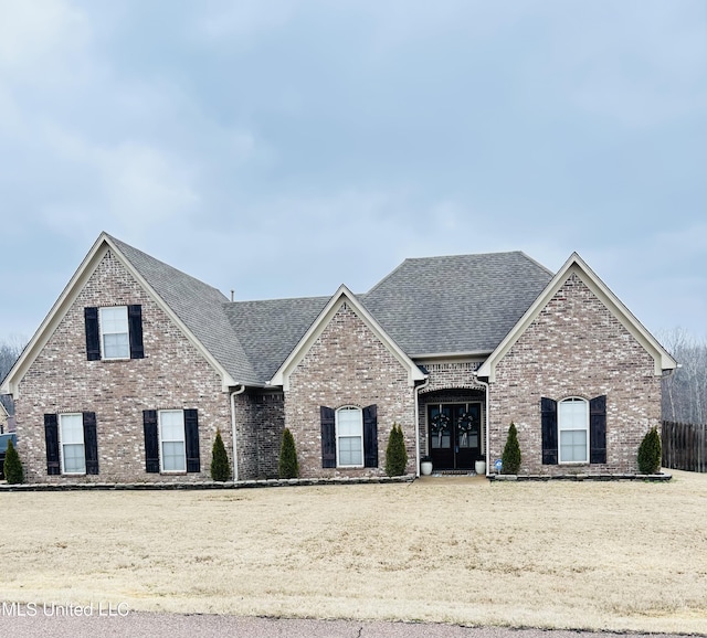 view of front of property featuring french doors and a front lawn