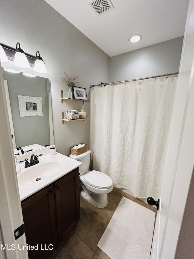 bathroom featuring vanity, tile patterned floors, and toilet