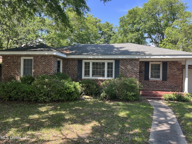 ranch-style house with brick siding, a front yard, and a garage