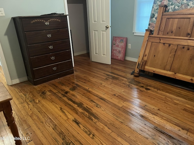bedroom with dark wood finished floors and baseboards