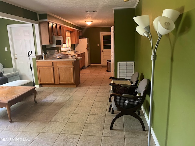 kitchen featuring a textured ceiling and white appliances