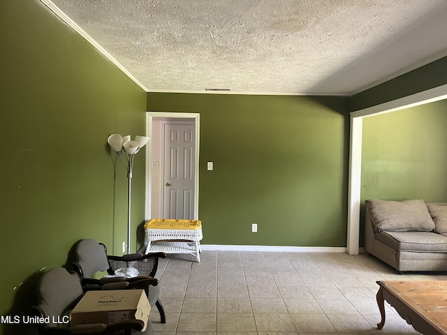 sitting room featuring tile patterned floors, baseboards, visible vents, and a textured ceiling