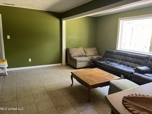 living room with baseboards, a textured ceiling, and visible vents