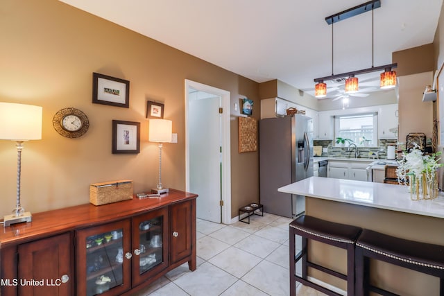 109 Palm Ave, Pass Christian, MS 39571 - kitchen featuring stainless steel fridge with ice dispenser, a kitchen bar, a sink, a peninsula, and light countertops