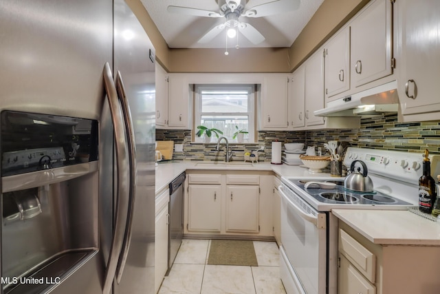 109 Palm Ave, Pass Christian, MS 39571 - kitchen featuring stainless steel appliances, under cabinet range hood, a sink, a ceiling fan, and light countertops