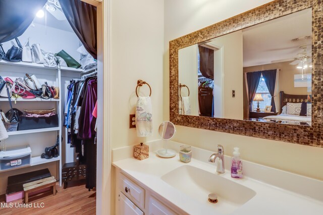 109 Palm Ave, Pass Christian, MS 39571 - bathroom featuring vanity, a ceiling fan, wood finished floors, and a spacious closet