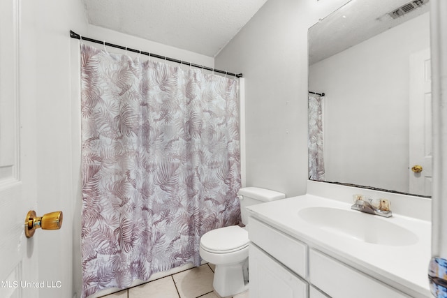 bathroom with a textured ceiling, toilet, vanity, curtained shower, and tile patterned flooring