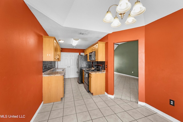 kitchen featuring stainless steel appliances, backsplash, sink, light stone countertops, and light tile patterned floors