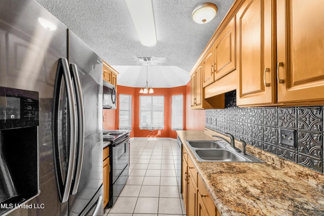 kitchen featuring sink, stainless steel appliances, decorative light fixtures, a notable chandelier, and light tile patterned floors