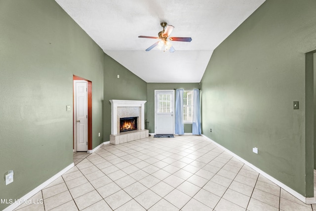 unfurnished living room featuring ceiling fan, light tile patterned floors, a fireplace, and vaulted ceiling