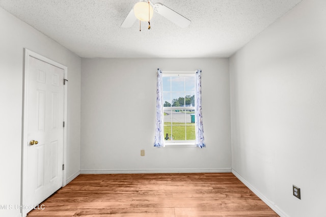 empty room featuring light hardwood / wood-style floors, a textured ceiling, and ceiling fan