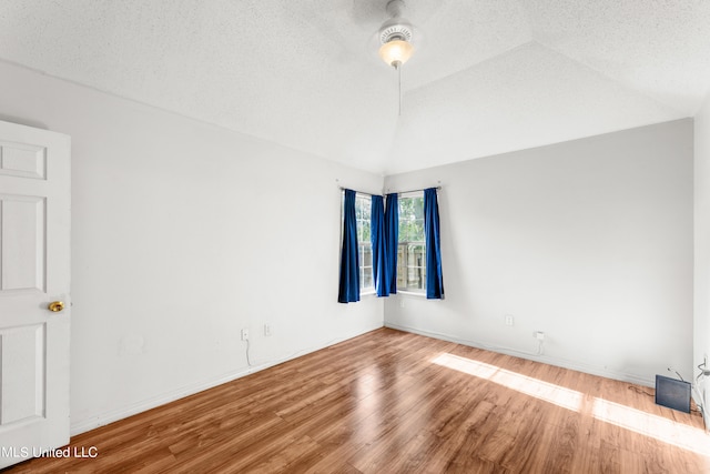 spare room featuring ceiling fan, a textured ceiling, wood-type flooring, and vaulted ceiling