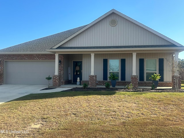 view of front of house with a garage, a front yard, and covered porch