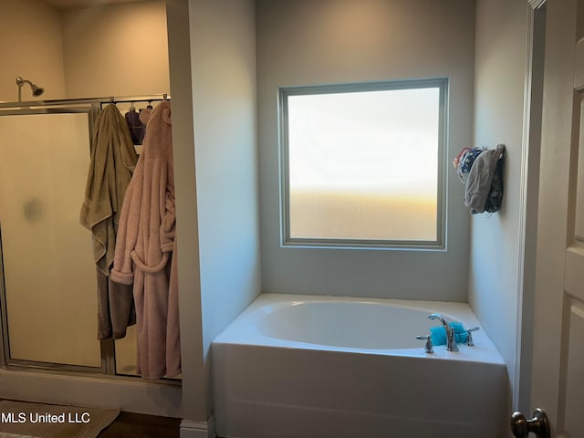 bathroom featuring shower with separate bathtub