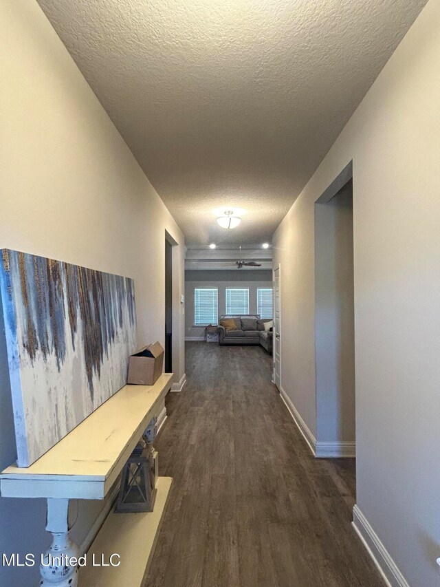 hallway with dark hardwood / wood-style floors and a textured ceiling