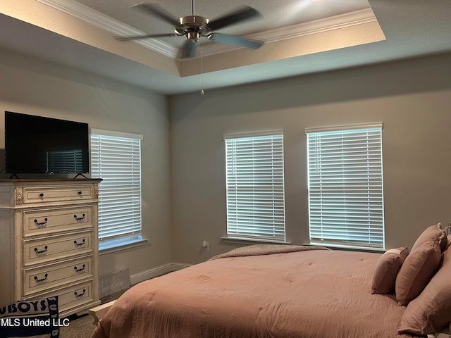 bedroom with a raised ceiling, ornamental molding, and ceiling fan