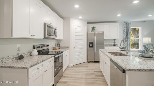 169 Mill Ct, Lucedale, MS 39452 - kitchen featuring stainless steel appliances, recessed lighting, light wood finished floors, white cabinetry, and a kitchen island with sink