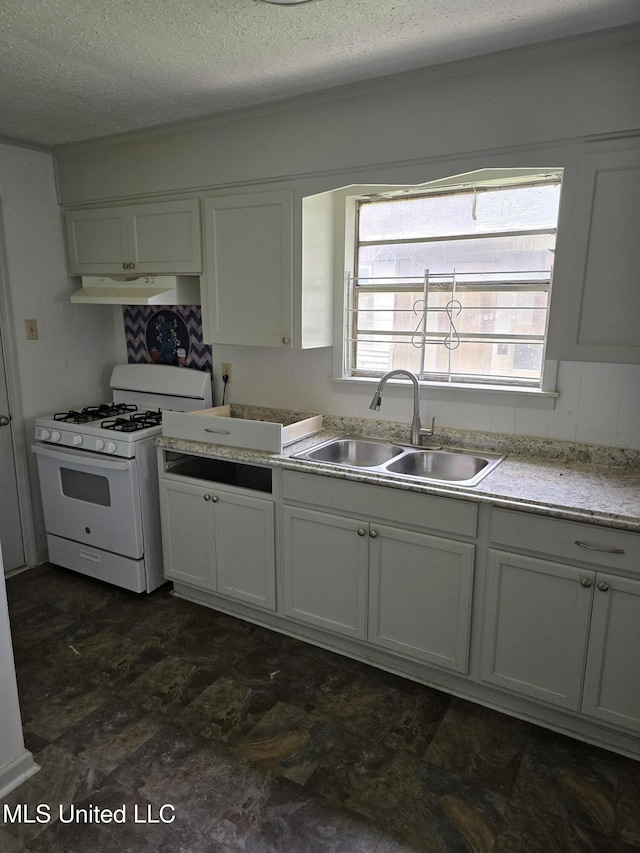 kitchen with white range with gas cooktop, white cabinets, light countertops, under cabinet range hood, and a sink