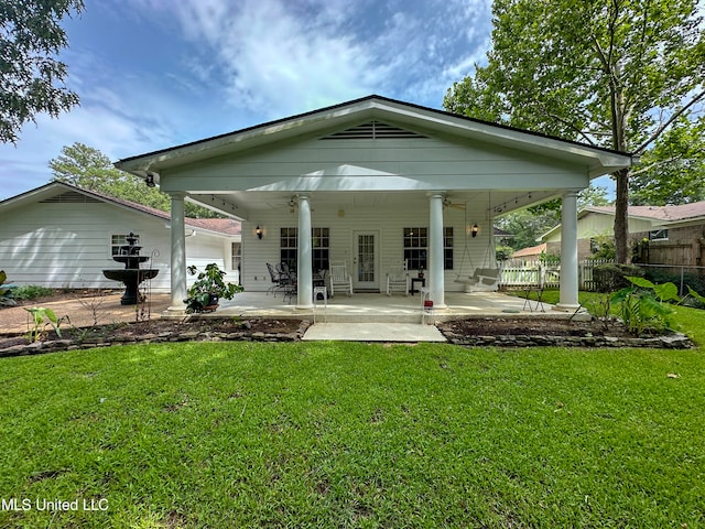 back of property featuring a patio, a lawn, and ceiling fan