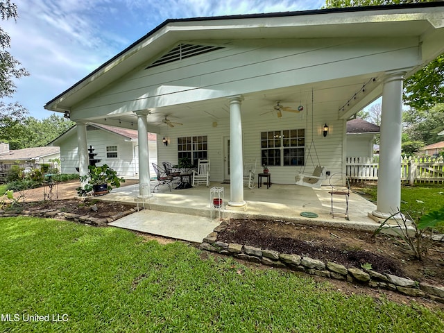 back of property with a patio, ceiling fan, and a lawn