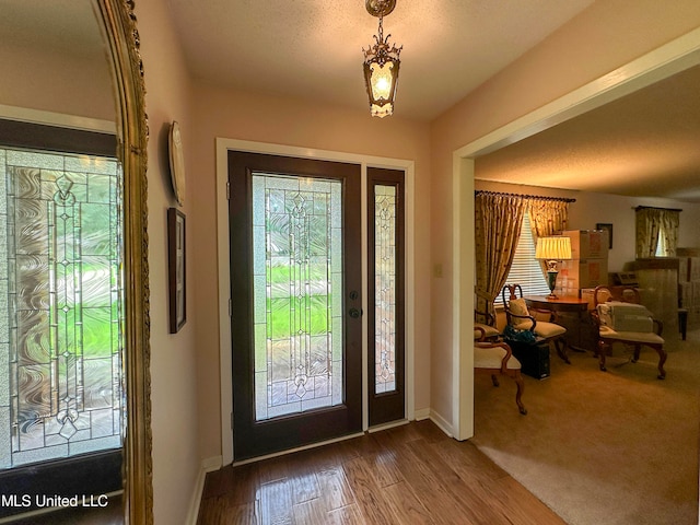 foyer entrance featuring hardwood / wood-style floors and a textured ceiling