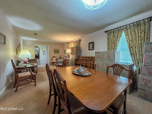 carpeted dining area featuring a textured ceiling