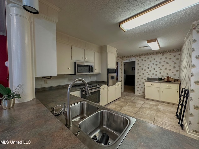 kitchen featuring white cabinetry, a textured ceiling, appliances with stainless steel finishes, and sink