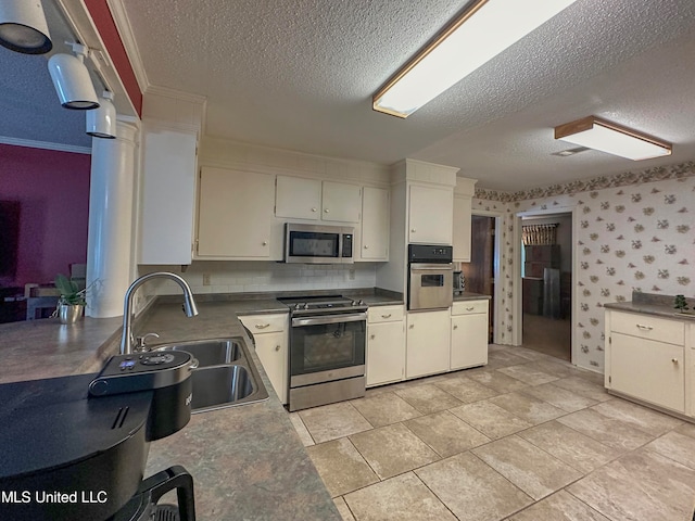 kitchen featuring white cabinetry, a textured ceiling, appliances with stainless steel finishes, and sink