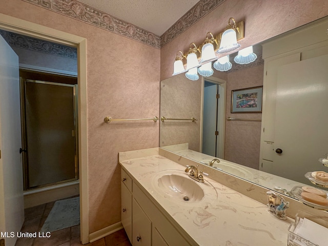 bathroom with vanity, tile patterned floors, a textured ceiling, and walk in shower