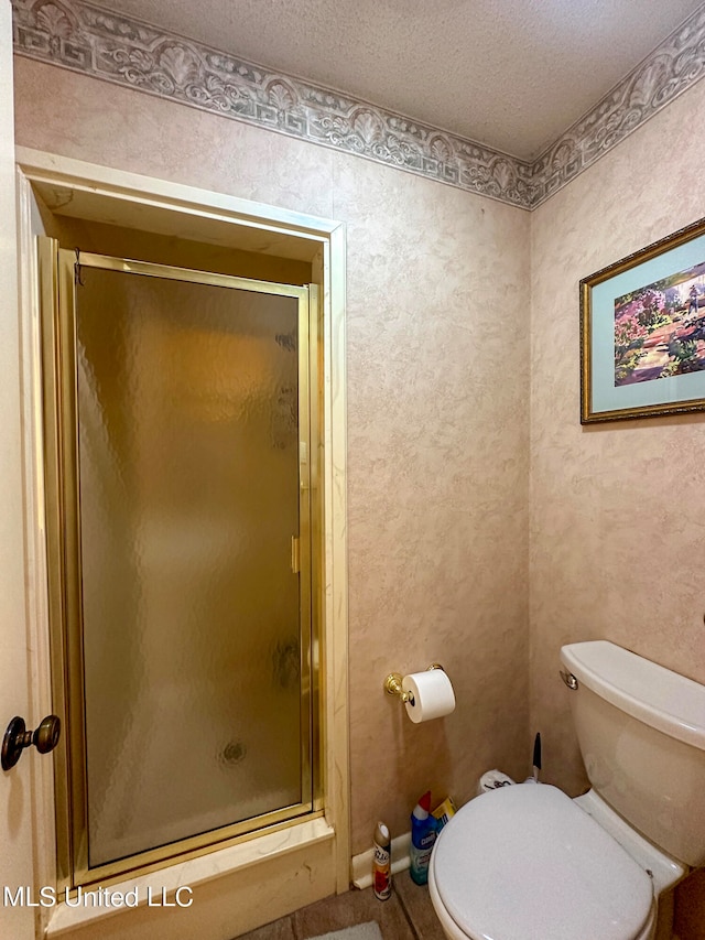 bathroom with a shower with door, a textured ceiling, and toilet