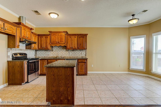 kitchen featuring a textured ceiling, light tile patterned floors, appliances with stainless steel finishes, and crown molding