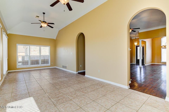 tiled empty room with vaulted ceiling and crown molding