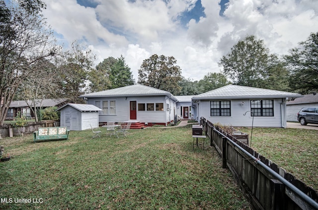 back of property featuring a storage shed and a yard