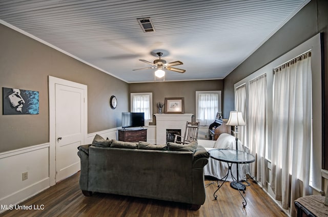 living room with dark hardwood / wood-style floors, crown molding, and ceiling fan