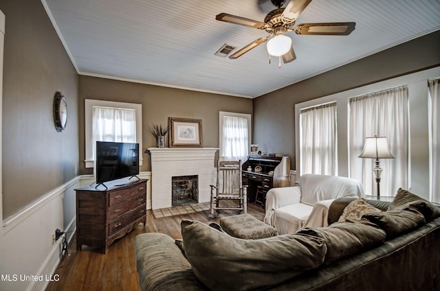 living room featuring a brick fireplace, plenty of natural light, hardwood / wood-style flooring, and ceiling fan