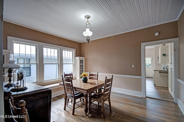 dining space with wood-type flooring and crown molding