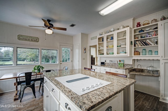 kitchen with a kitchen island, white electric cooktop, dark hardwood / wood-style floors, and white cabinets