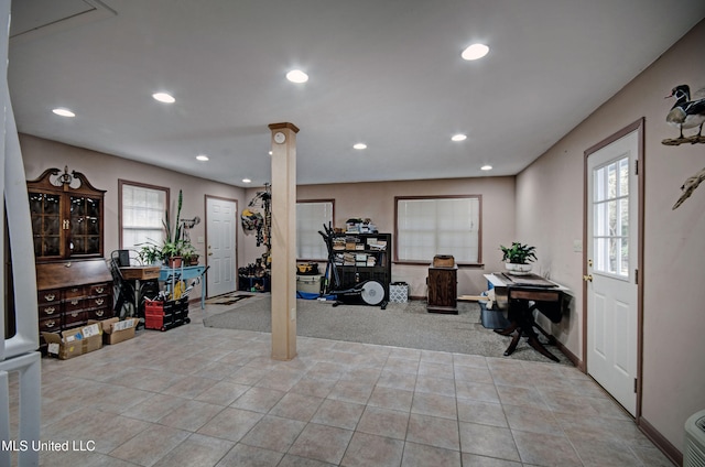 exercise area featuring ornate columns, light carpet, and a healthy amount of sunlight