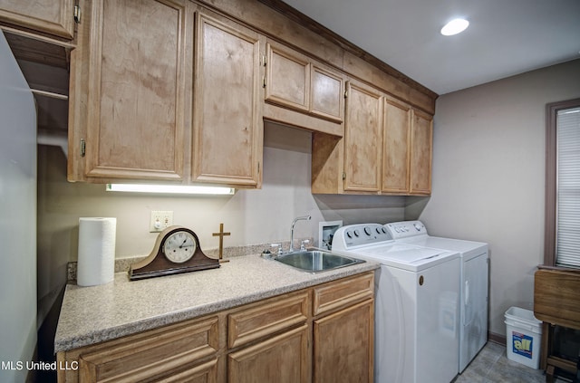 laundry area featuring cabinets, sink, and washer and clothes dryer